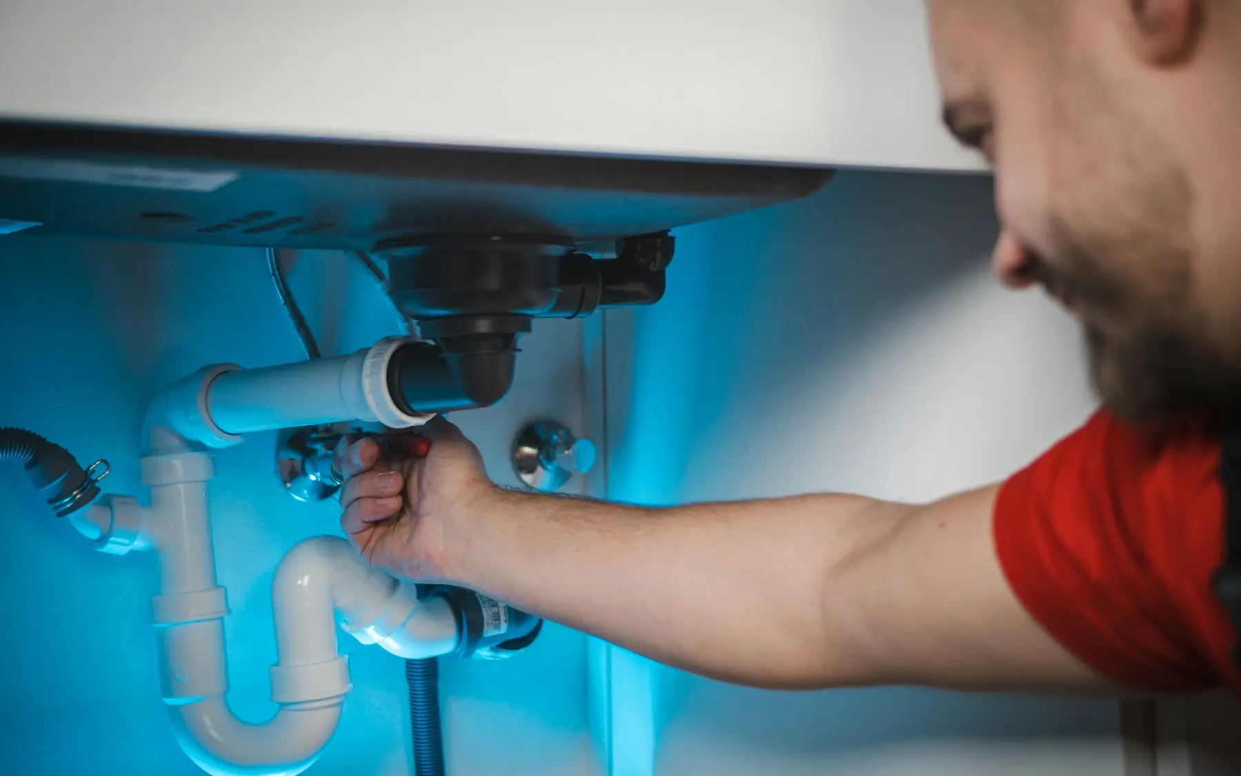 A plumber working under a sink