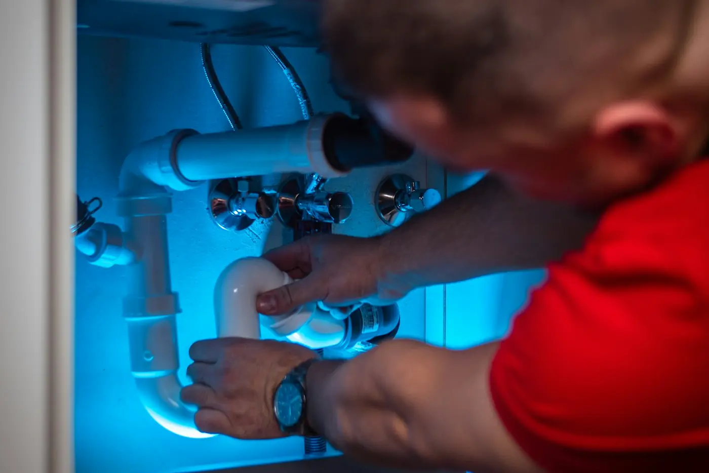 A plumber at a cabinet